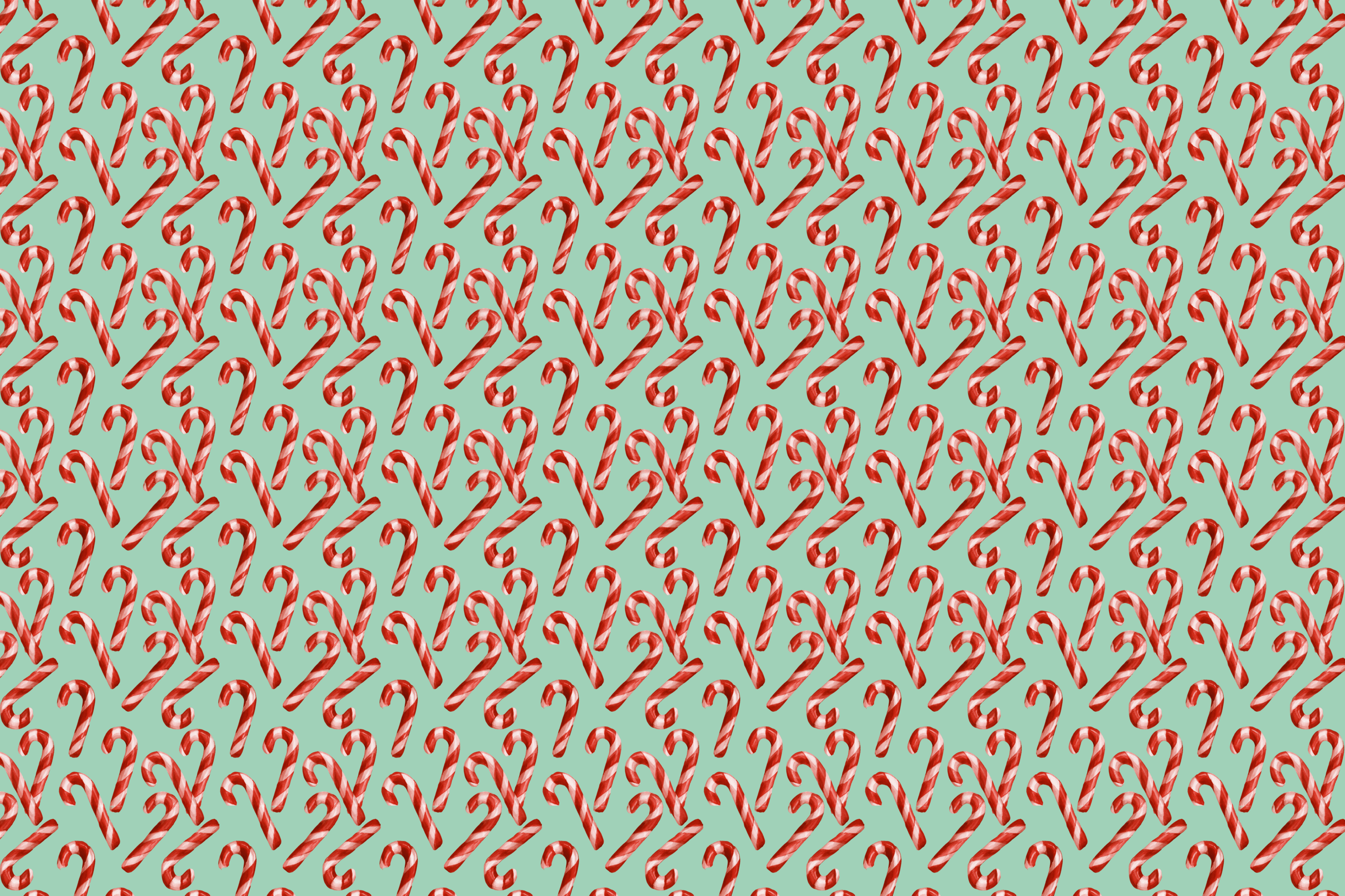 Seamless Christmas pattern featuring red and white striped candy canes on a mint green background.