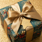 Luxury floral Christmas wrapping paper with gold satin bow on teal gift box, by Wrapped Studios.