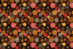 Seamless pattern with circular starbursts and textured dots in shades of gold, brown, and red on black.