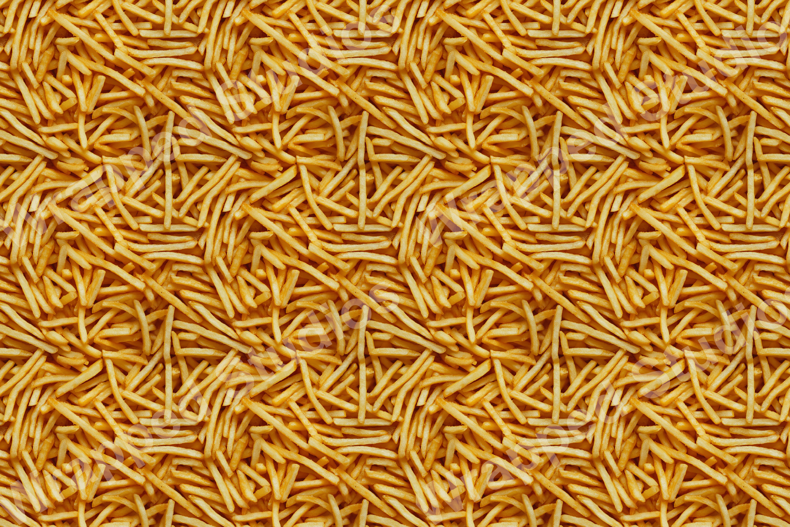 All-over food pattern of tightly packed golden yellow french fries creates a textured abstract design.