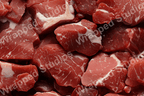 Abstract pattern of raw meat chunks with white marbling, in various shades of red.