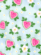 Watercolor pattern featuring pink heart-shaped watermelon slices and white flowers on a light blue background.