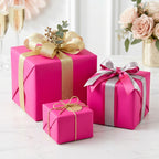 Three hot pink gift boxes with decorative ribbons on a light surface.