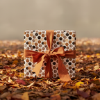 Rustic brown polka dot wrapping paper with an orange ribbon bow, perfect for autumn gifts or fall birthdays.