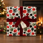 Festive holiday wrapping paper with a red and green modern abstract pattern, tied with a luxurious deep red velvet ribbon and "Joyful Moments" tag.