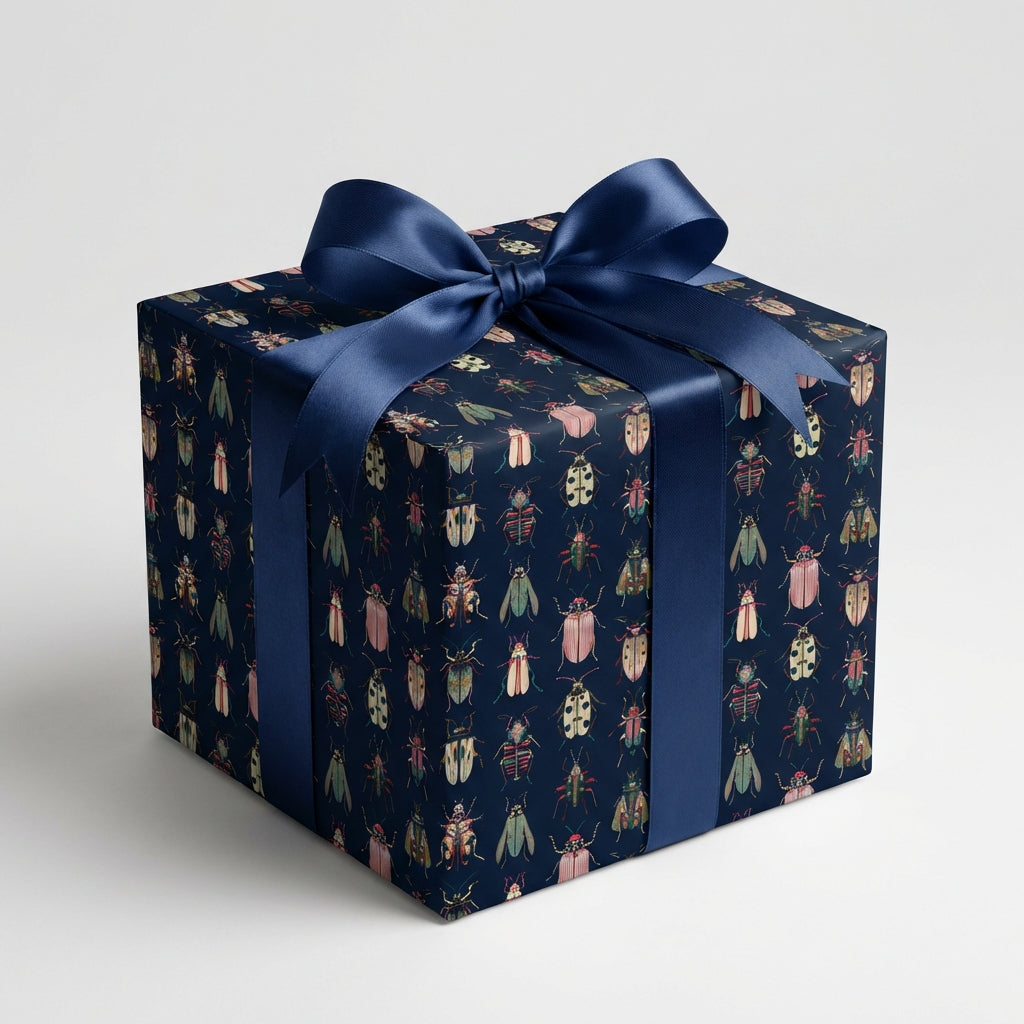 Navy gift box wrapped in insect-patterned paper with a satin ribbon for a unique birthday gift wrap.