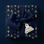 Luxury gift wrapped in navy beetle print paper with a wide ribbon and "A little specimen" tag.
