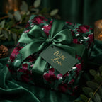 Elegant floral wrapping paper in deep green and burgundy, tied with a satin bow and "With Love" tag.