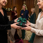 Woman exchanging a Wrapped Studios floral gift with green ribbon at Christmas party.