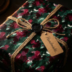 Handmade gift wrapped in painterly floral wrapping paper with twine and wax seal.