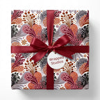 Boho floral wrapping paper with burgundy satin ribbon on a gift box by Wrapped Studios.