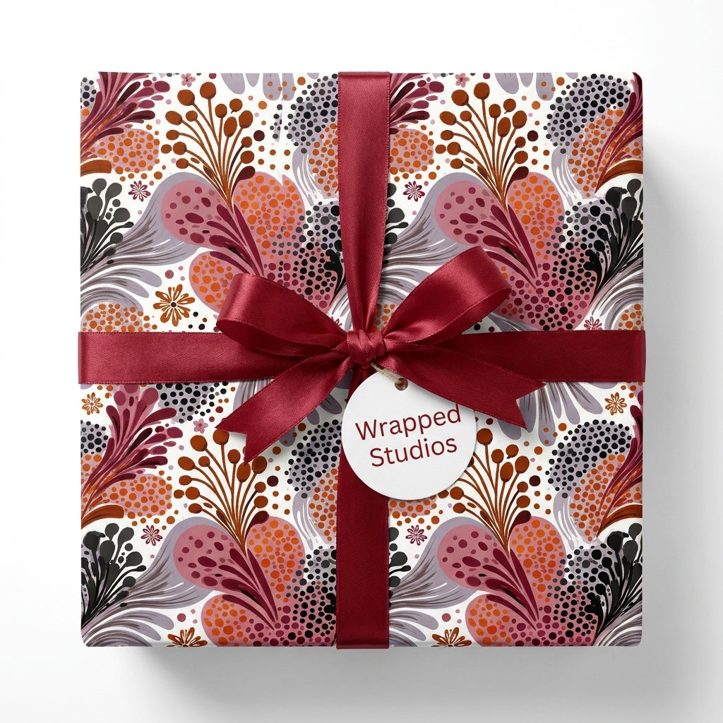 Boho floral wrapping paper with burgundy satin ribbon on a gift box by Wrapped Studios.