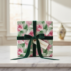 Modern geometric wrapping paper with pink and green triangles, tied with a luxurious green velvet ribbon and "Special Gift" tag on a white marble table.