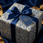 Luxury gift box in navy and gold mosaic wrapping paper, tied with a satin ribbon and a "For You" tag by Wrapped Studios.