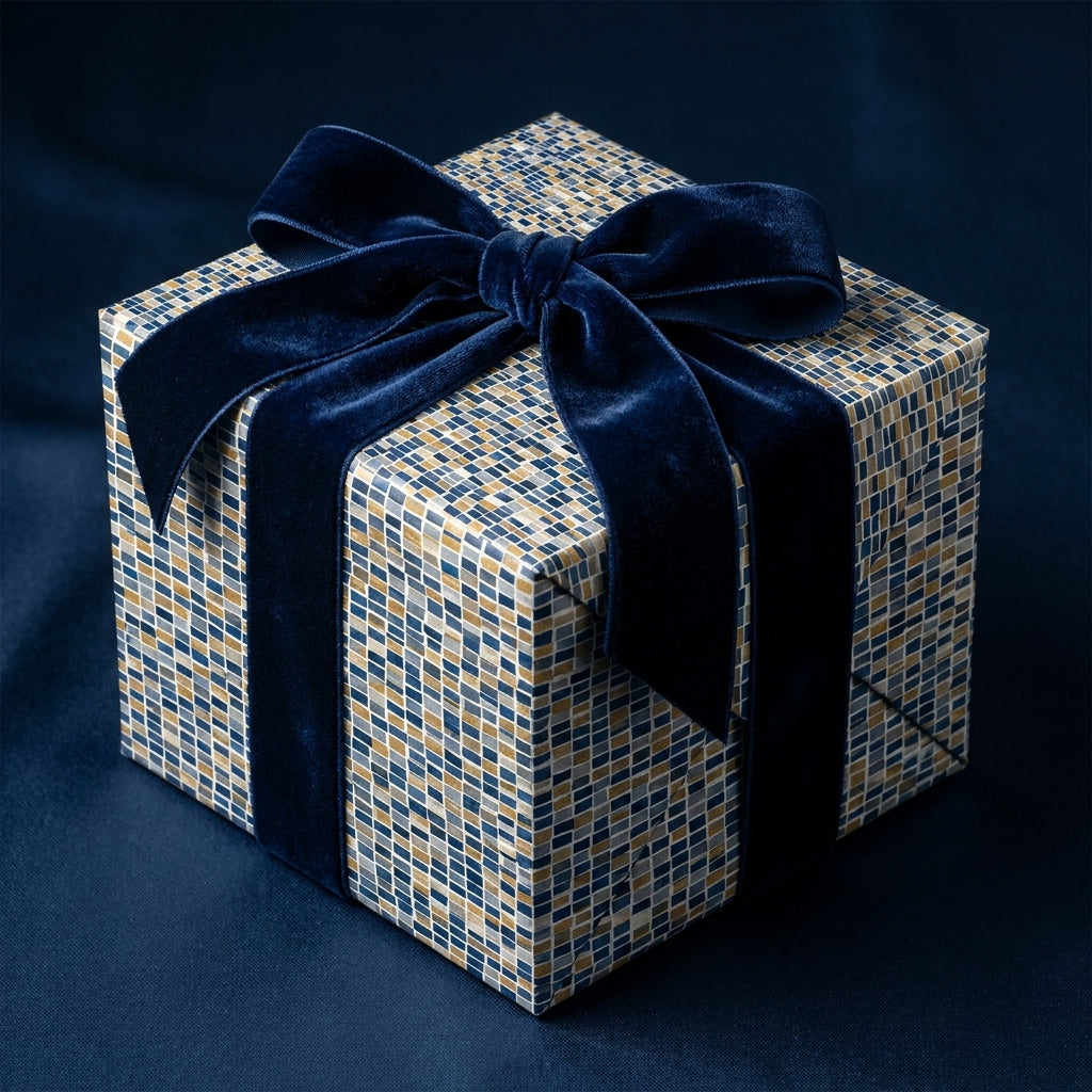 Luxury gift box wrapped in gold and blue mosaic paper with a velvet navy blue bow by Wrapped Studios.