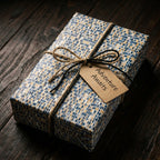 Gift wrapped in modern blue and gold mosaic paper with twine and an Adventure Awaits tag by Wrapped Studios.