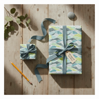 Modern wave pattern gift wrap in green and blue, tied with a blue ribbon, on a rustic wooden table with eucalyptus.