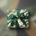 Elegant gift wrapped in modern green wave pattern paper with satin ribbon.