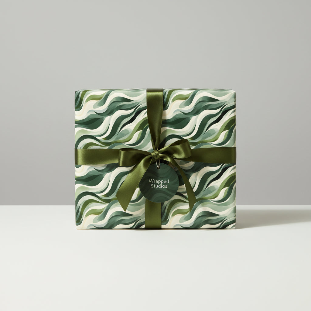 Gift box in modern wave-patterned wrapping paper, tied with an olive green ribbon, from Wrapped Studios.