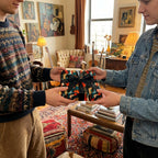 Two friends exchange a gift in artistic retro wrapping paper with a black bow by Wrapped Studios.
