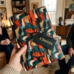 Retro guitar wrapping paper by Wrapped Studios on a gift with a black Cheers tag.