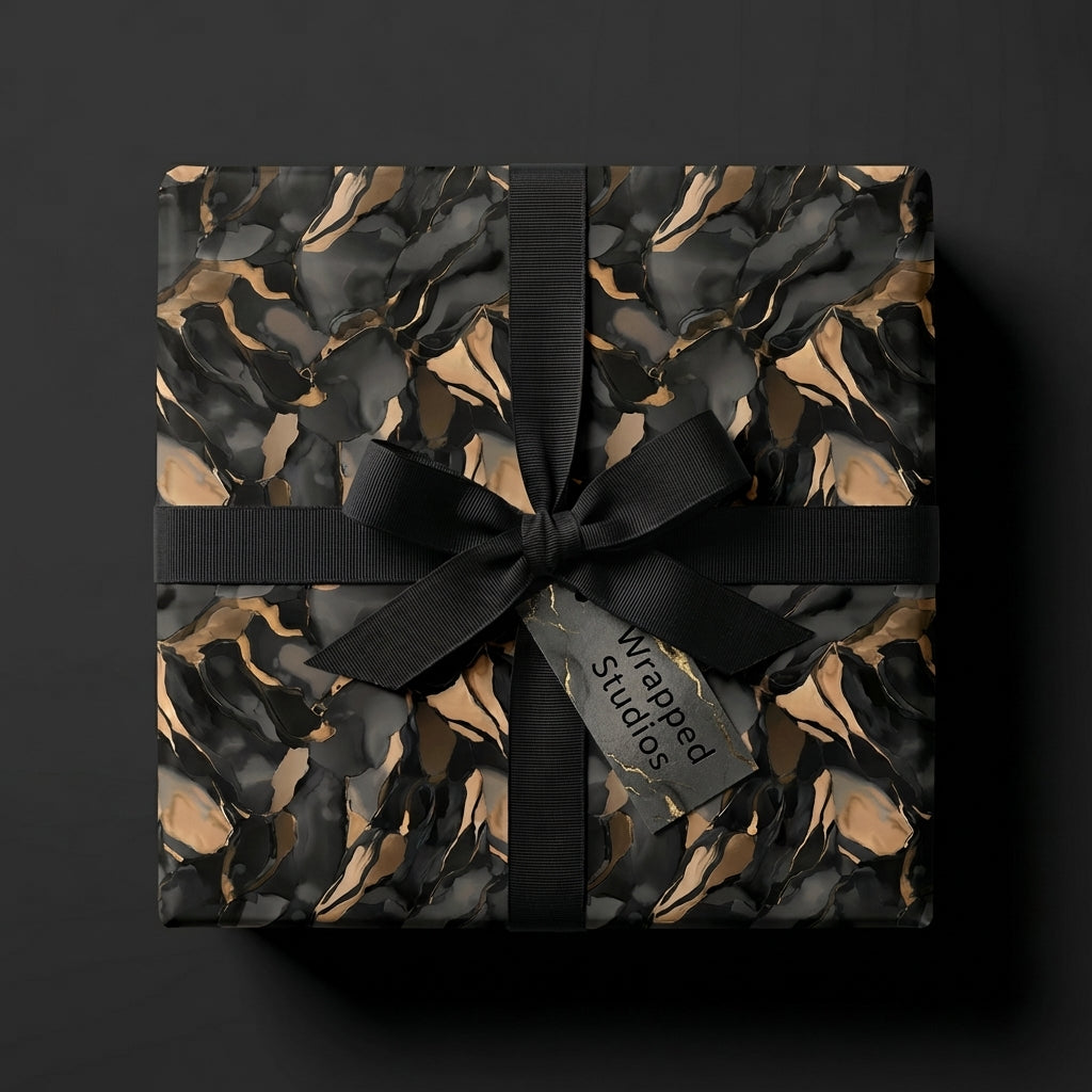 Luxury gift wrapped in Wrapped Studios black and gold marble pattern wrapping paper with a satin ribbon.