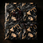 Luxury gift wrap featuring a black and gold marble pattern, tied with twine and ribbon.