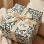 Minimalist black and white wrapping paper with a cream velvet bow and gift tag by Wrapped Studios.
