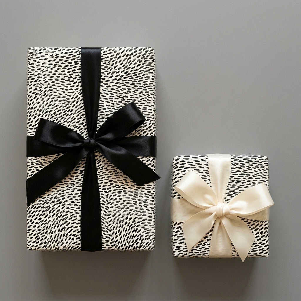 Minimalist black and white wrapping paper with satin bows. Luxury modern gift wrap by Wrapped Studios.