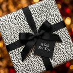Modern black and white wrapping paper with a black bow on a luxury holiday gift box by Wrapped Studios.