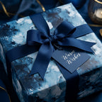 Luxury navy blue abstract wrapping paper with a matching ribbon and holiday gift tag by Wrapped Studios.