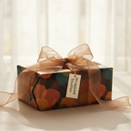 Modern abstract birthday gift wrap with a sheer brown organza ribbon and "Wrapped Studios" tag, perfect for luxury gifting.