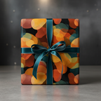 Modern abstract wrapping paper with warm orange, yellow, and red shapes on black, tied with a teal ribbon and bow, perfect for unique gifts.