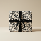 Modern abstract black and beige wrapping paper with a black velvet ribbon bow, perfect for luxury gifts or minimalist celebrations.