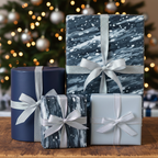 Modern Christmas gift wrap: gray and blue patterned wrapping paper with silver glitter ribbon on various sized boxes.