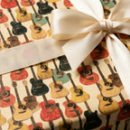Retro acoustic guitar wrapping paper on a gift box with a cream satin ribbon bow, by Wrapped Studios.