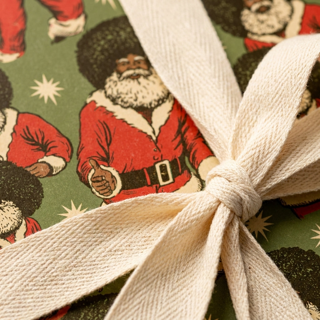 Black Santa Christmas wrapping paper on a gift tied with a cream cotton ribbon by Wrapped Studios.