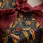 Rustic gift wrap featuring feather designs and a frayed burgundy ribbon.