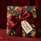 Gift wrapped in rustic floral wrapping paper with red ribbon and "Wrapped Studios" tag.