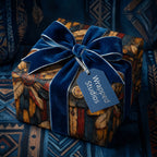 Elegant gift box wrapped in feather pattern wrapping paper, adorned with a blue velvet bow.