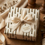 Rustic bullet wrapping paper with a cream ribbon bow and gift tag from Wrapped Studios.