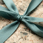 Vintage map wrapping paper tied with a dusty teal ribbon, luxury gift wrap by Wrapped Studios.