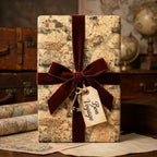 Vintage map wrapping paper with a velvet bow and Bon Voyage tag by Wrapped Studios.