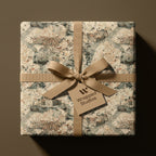 Vintage map luxury wrapping paper by Wrapped Studios, tied with a beige ribbon bow.
