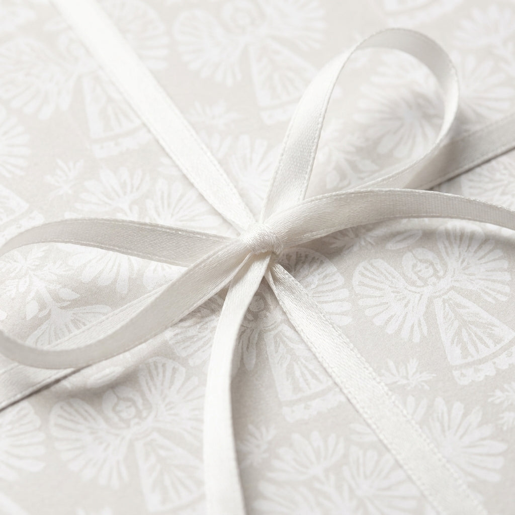 Elegant white angel Christmas wrapping paper with a satin ribbon bow, by Wrapped Studios.