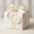 Luxury Christmas wrapping paper with elegant angel pattern and ivory satin bow by Wrapped Studios.