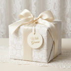 Luxury Christmas wrapping paper with elegant angel pattern and ivory satin bow by Wrapped Studios.