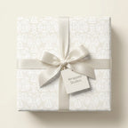 Elegant cream angel wrapping paper with satin bow, luxury Christmas gift wrap by Wrapped Studios.