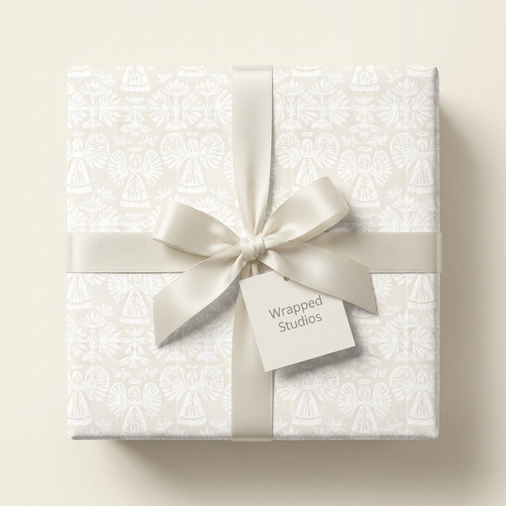Elegant cream angel wrapping paper with satin bow, luxury Christmas gift wrap by Wrapped Studios.