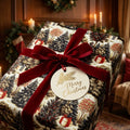 Vintage Christmas wrapping paper with winter tree print and red velvet bow by Wrapped Studios.